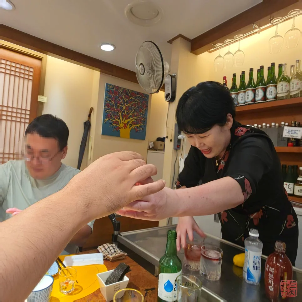 Serving a refreshing somaek to a customer at Goldtuna Jumakase
